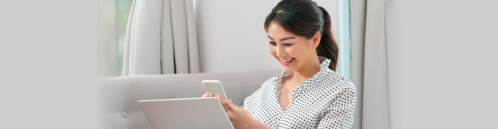 woman using mobile phone and laptop